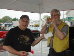 Lion Jerry stands ready with napkins as Lion Gary chomps into a veggie burger